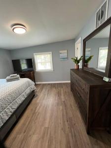 1 dormitorio con cama, tocador y espejo en Beautifully Acquainted Home. Close to DT GSO! en Greensboro