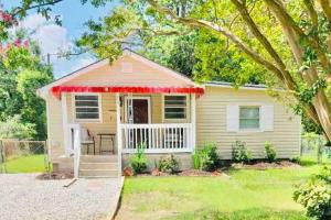 a small yellow house with a red awning at Beautifully Acquainted Home. Close to DT GSO! in Greensboro