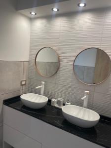 dois lavatórios num balcão numa casa de banho com dois espelhos em Casa Soñada Solo uso familiar no fiestas no reuniones em Paraná