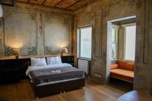 a bedroom with a bed and a couch and two windows at Rooms Galata in Istanbul