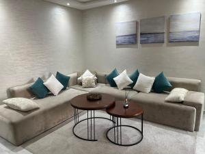 ein Wohnzimmer mit einem Sofa mit blauen und weißen Kissen in der Unterkunft Miramare Cosy appartement pied dans l'eau avec piscine in Mohammedia