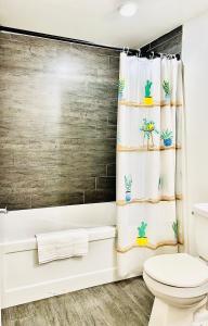 a bathroom with a toilet and a shower curtain with cactus at LaVida Exclusive Guest House, Free Parking (Rm#2) in London