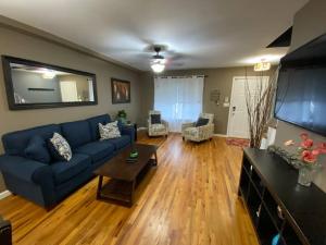 a living room with a blue couch and a table at Casa Rosado @ NYC Home Pool Firepit Parking Ferry in Clifton