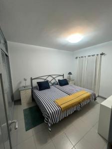 a bedroom with a bed with a black and white striped blanket at Casa marea in Puerto Calero