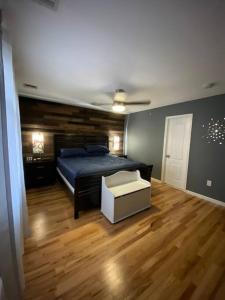 Schlafzimmer mit einem Bett und Holzboden in der Unterkunft Casa Rosado @ NYC Home Pool Firepit Parking Ferry in Clifton