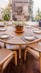uma mesa de madeira com pratos e copos em Casa Montejo Merida em Mérida