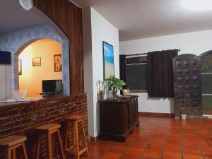 a room with a bar with stools and a table at Chácara Monteiro - Próximo ao Thermas Water Park in São Pedro