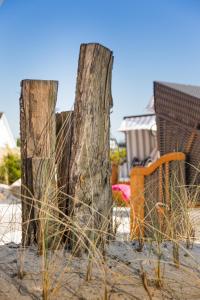 two wooden posts in the sand on a beach at Hotel Twilling in Sankt Peter-Ording