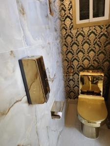 a bathroom with a gold toilet and a sink at Luxueux platinium in Libreville