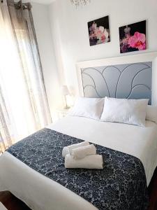 1 dormitorio con 1 cama con 2 toallas en Casa Blanca en Sevilla