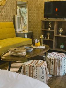 a living room with a yellow couch and a coffee table at Four caravan in AlUla