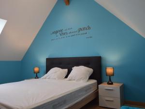 une chambre avec un lit avec un mur bleu dans l'établissement Grande Maison de Campagne avec Jardin Clos, Proche Levroux, 12 Pers., Châteaux, Zoo de Beauval - FR-1-591-176, à Levroux