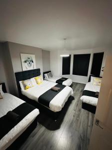 a hotel room with three beds and windows at Melior Grandiose in Liverpool