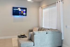 a living room with a couch and a flat screen tv at Chic City Oasis • King Suite 3BR/2.5BA• Near Downtown & NRG in Houston
