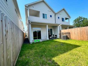 a white house with a fence and a yard at Chic City Oasis • King Suite 3BR/2.5BA• Near Downtown & NRG in Houston