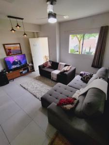 un soggiorno con divano e TV di Casa com piscina privativa, 2 suítes, Sahy. a Mangaratiba