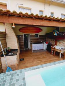 um pátio aberto com uma piscina e uma prancha de surf em Casa com piscina privativa, 2 suítes, Sahy. em Mangaratiba