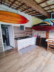 a room with a kitchen with a surfboard hanging from the ceiling at Casa com piscina privativa, 2 suítes, Sahy. in Mangaratiba