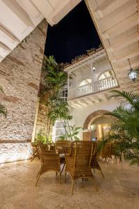 eine Terrasse mit einem Tisch und Stühlen in einem Gebäude in der Unterkunft Hotel Casa del Gobernador in Cartagena de Indias