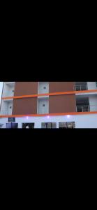 ein Apartmenthaus in Orange und Weiß in der Unterkunft Florida Pool & Grill in Nouakchott
