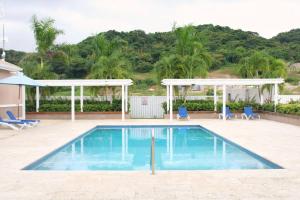 una piscina con 2 sillas y un cenador en CasaLamar Beachside Retreat, en Point