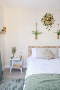 ein Schlafzimmer mit einem Bett und einem Tisch mit Pflanzen in der Unterkunft CasaLamar Beachside Retreat in Point
