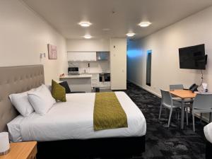 a hotel room with a bed and a kitchen at Zeta Motel in Hamilton