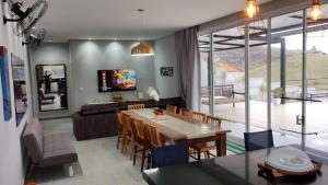 a dining room and living room with a table and chairs at Esquina do Sossego in Igaratá