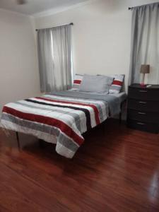 uma cama com um cobertor listrado num quarto em Simple Private Bedroom # 2 em Alexandria