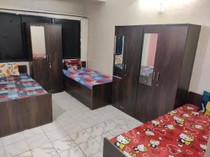 a room with three beds and wooden cabinets at sri rama krishna pg in Pune