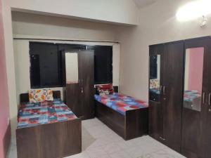 two beds in a room with wooden cabinets at sri rama krishna pg in Pune