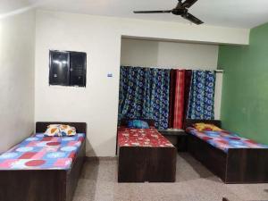 a room with two beds and a ceiling at sri rama krishna pg in Pune
