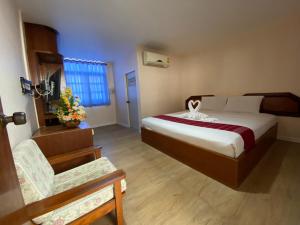 Imperial Sakon Hotel في محافظة ساكون ناخون: غرفه فندقيه بسرير وكرسي