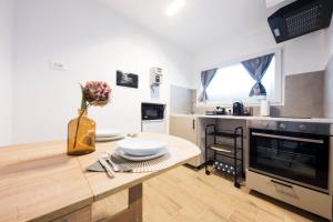 a kitchen with a table with a vase of flowers on it at Castelletto - Appartamento+P. Auto : La Funicolare in Genova