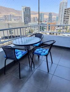 a table and chairs on a balcony with a view at Frente al mar, zona exclusiva de Iquique in Iquique