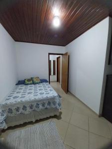 Praia inglesese في فلوريانوبوليس: غرفة نوم بسرير وسقف خشبي