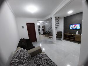 Praia inglesese في فلوريانوبوليس: غرفة معيشة مع أريكة وتلفزيون بشاشة مسطحة