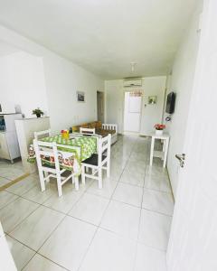 a room with a table and chairs and a kitchen at Pousada Ilha dos Corais in Palhoça