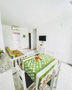 a dining room with a table and chairs and a television at Pousada Ilha dos Corais in Palhoça