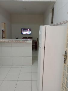 um frigorífico branco num quarto com uma televisão em AM-RR Hostel em Manaus