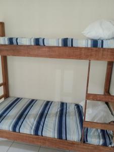 two bunk beds with blue and white striped sheets at AM-RR Hostel in Manaus