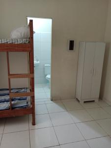 a room with a bunk bed and a bathroom with a toilet at AM-RR Hostel in Manaus