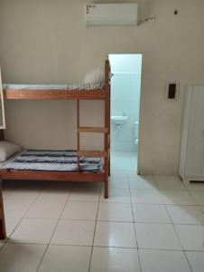 a room with two bunk beds and a bathroom at AM-RR Hostel in Manaus