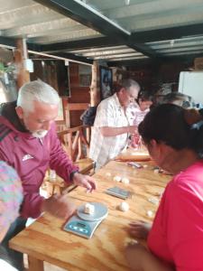 Eine Gruppe von Menschen, die um einen Tisch sitzen und ein Spiel spielen. in der Unterkunft Hostal Ñuca Huasi in Tambillo