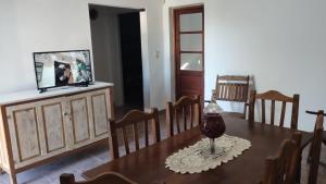 a dining room with a table and chairs and a television at JOAQUINA in Ramallo