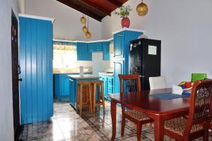 a kitchen with blue cabinets and a wooden table at Elegant Rays Apartment- Golf Course , Grenada in Grand Anse