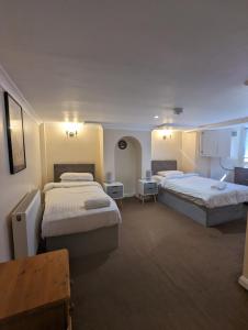 a hotel room with two beds and a table at Welcoming Flat By Kasar Stays in Gillingham