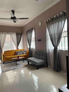 un soggiorno con divano giallo e finestre di Ruma.TigaPulohLapan @ Gambang Damai a Gambang