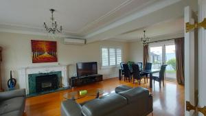 a living room with a couch and a table and chairs at Elegant Home with Seaview in Auckland