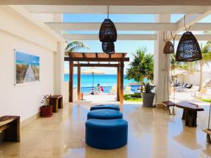 a living room with blue ottomans and the beach at A 2 minutos caminando de COCO BONGO! vista al mar - Od110 - in Cancún